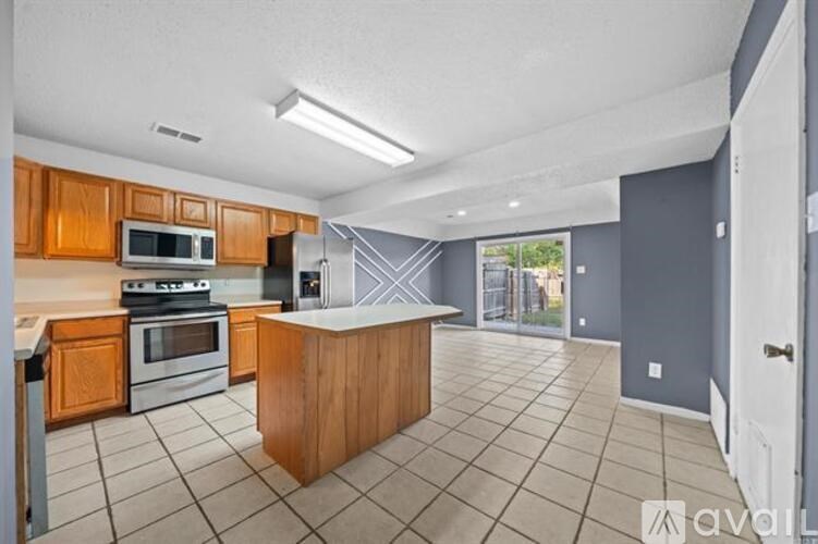 A kitchen with wooden cabinets and a tiled floor.