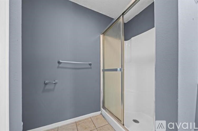 A bathroom with a walk-in shower and a towel bar.