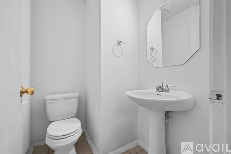 A white toilet and sink in a bathroom.