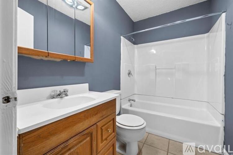 A bathroom with a white sink, toilet, and bathtub.