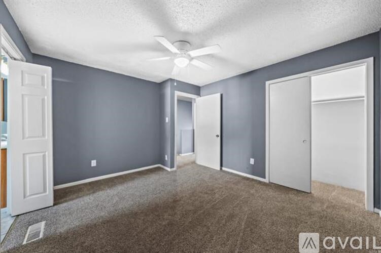 A room with grey walls and a ceiling fan.