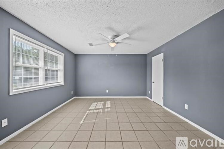 A room with a ceiling fan and a window.