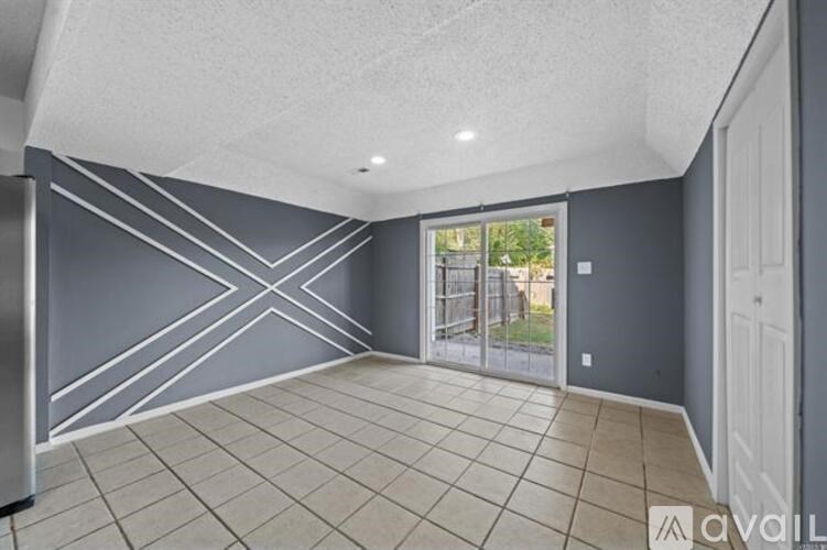A spacious room with grey walls and a large window.