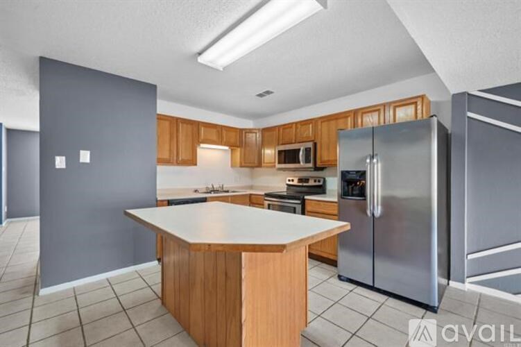 A kitchen with a refrigerator, microwave, and oven.