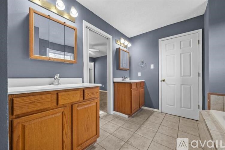 A bathroom with a white sink and wooden cabinetry.