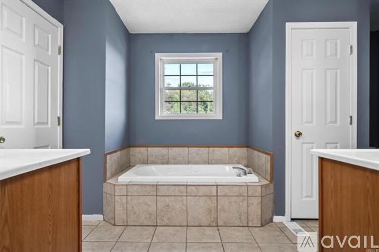 A bathroom with blue walls and a large window.