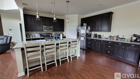 A kitchen with black cabinets and a white island.
