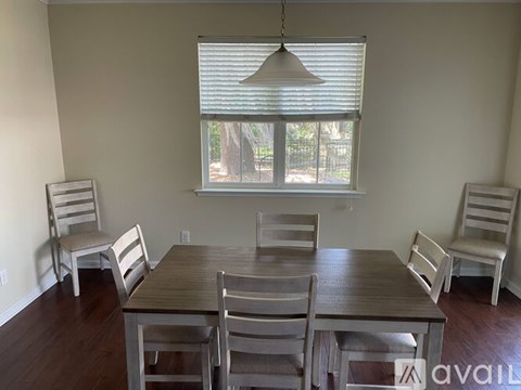A dining room with a table and chairs.