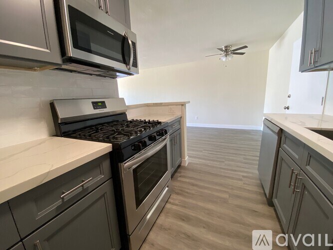 A kitchen with a stove top oven and a microwave above it.