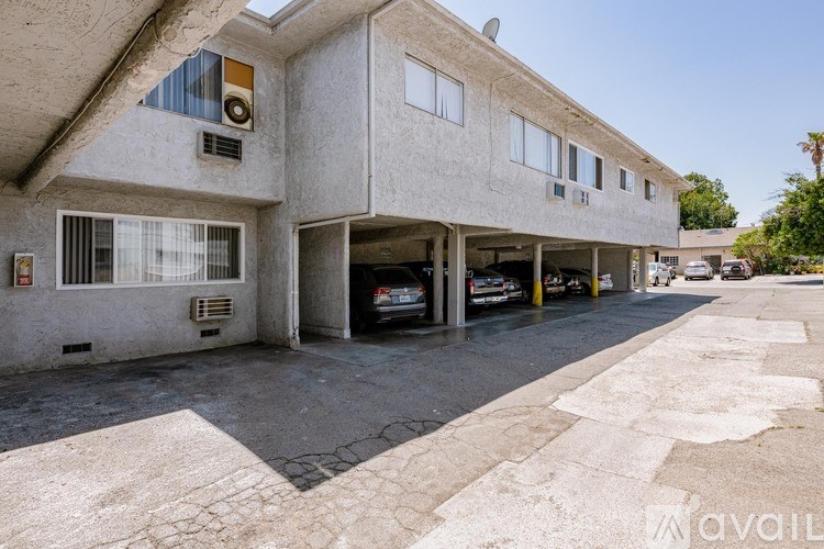 A concrete building with a parking garage in front.