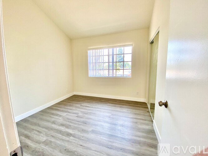 A room with a window and a door is available for rent.