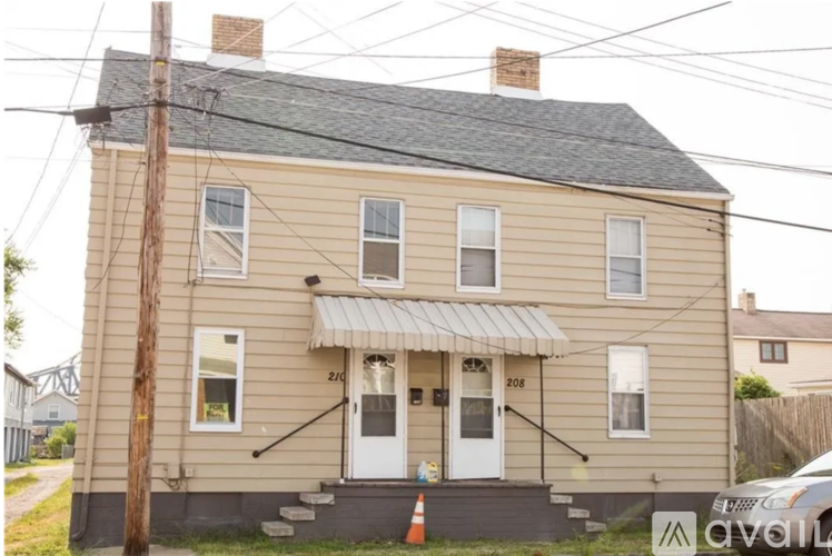 A two-story house with a white door and awnings on the front.