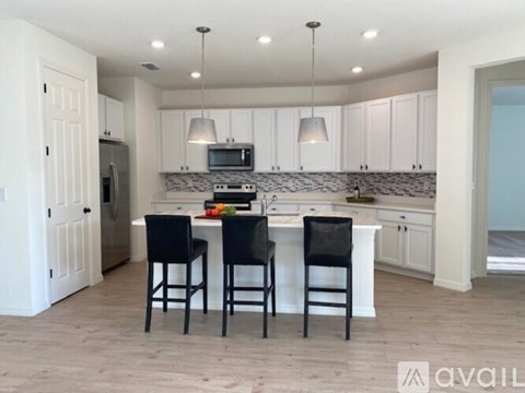 A kitchen with white cabinets and a black countertop.