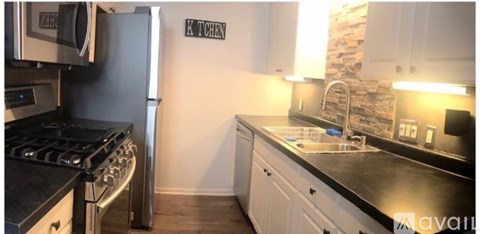 A kitchen with a black counter top and white cabinets.