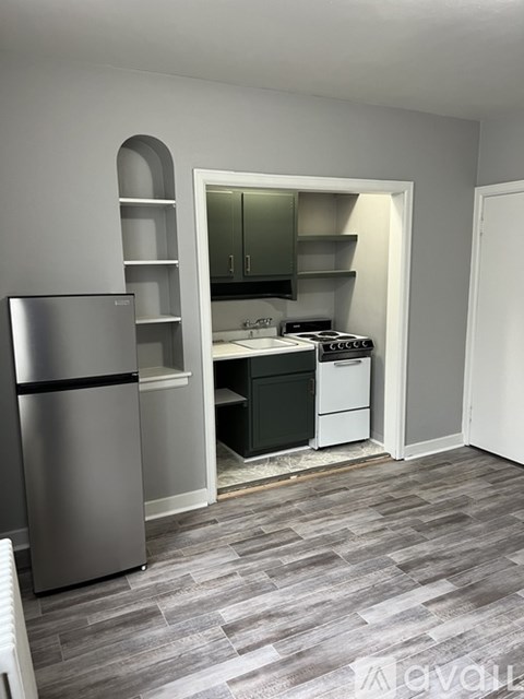 A kitchen with a refrigerator and a stove top oven.