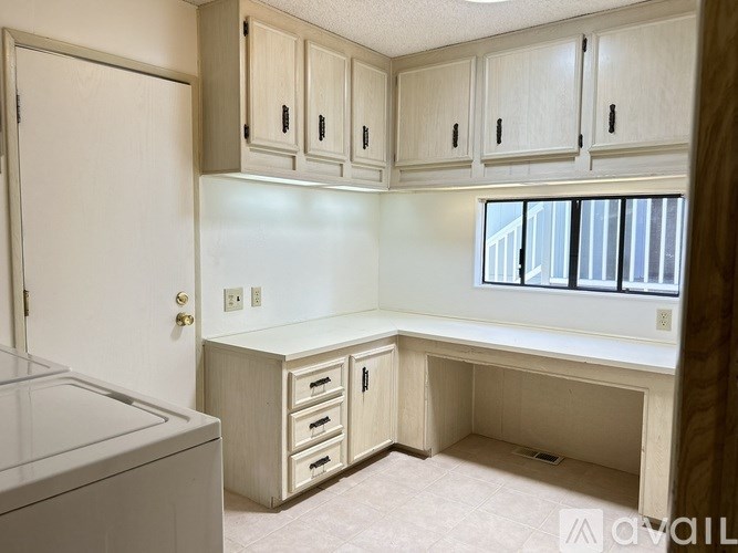 A kitchen with white cabinets and a white dishwasher.