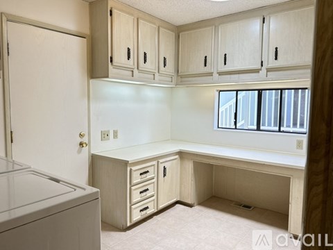 A kitchen with white cabinets and a white dishwasher.