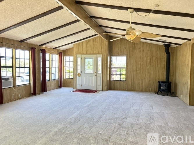 A spacious room with wooden walls and a white door.
