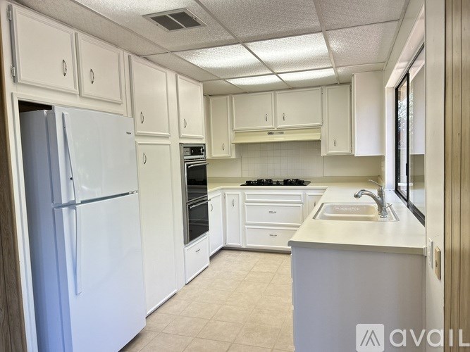 A kitchen with white appliances and cabinets.