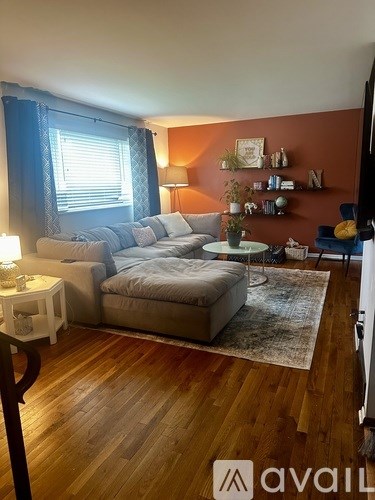 A living room with a grey couch and a white side table.