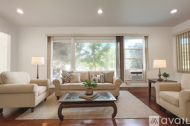 A modern living room with a large sectional sofa and a coffee table in the center.