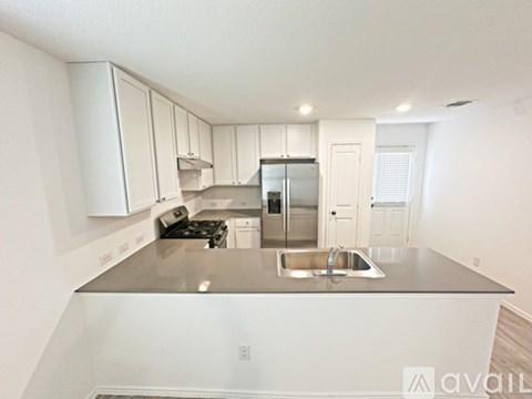 A kitchen with white cabinets and a stainless steel island.