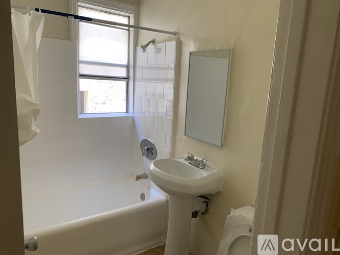 A bathroom with a white tub, sink, and mirror.