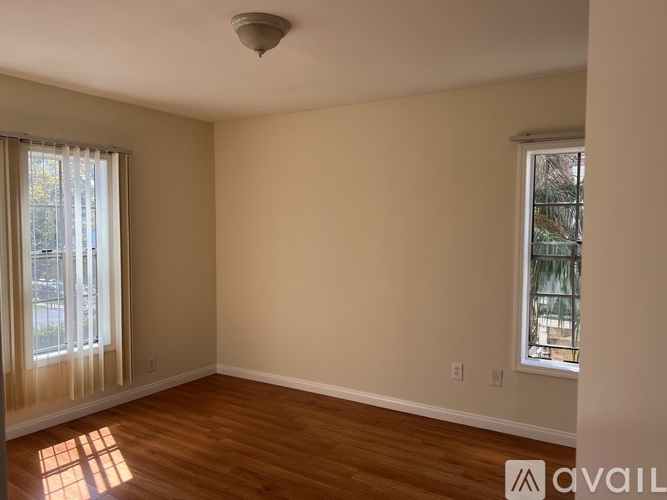 A room with wooden floors and two windows.