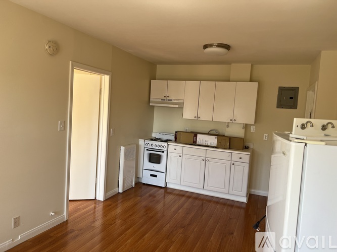 A kitchen with white appliances and cabinets is available for rent.