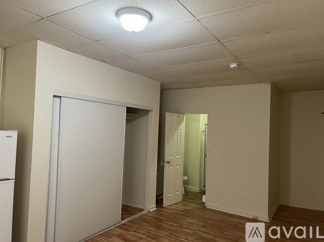 A room with a white fridge and a white door.