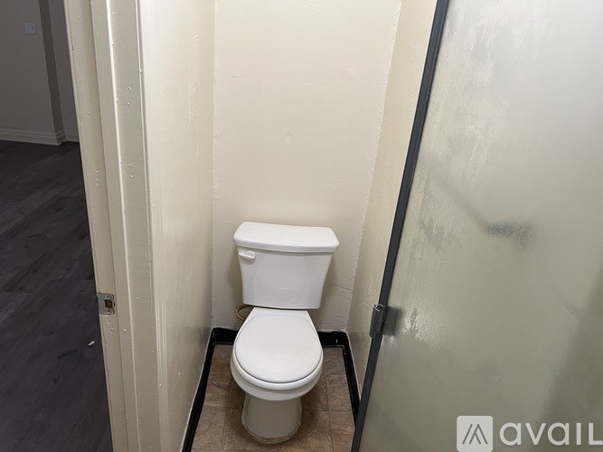 A white toilet in a small bathroom.