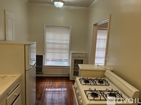 A kitchen with a white stove and a white refrigerator.