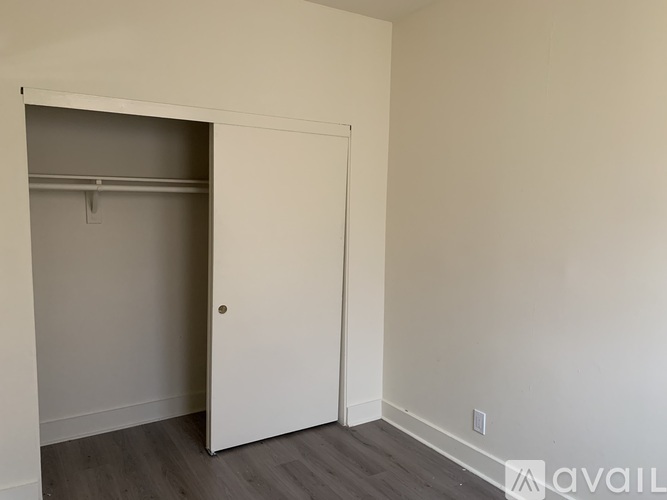 A room with a white door and a grey wall.
