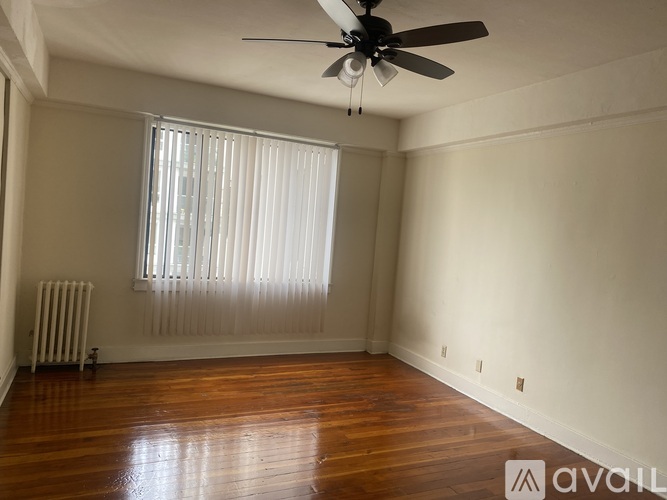 A room with a ceiling fan and wooden flooring.