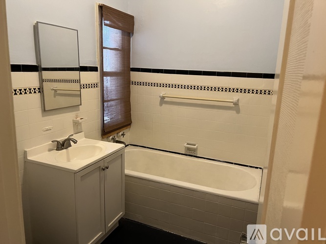 A bathroom with a white sink and bathtub.