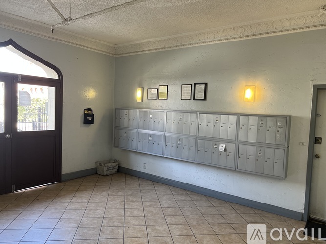 A room with a wall of mailboxes and two wall-mounted lights.