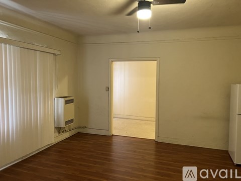 A room with wooden flooring and a ceiling fan.