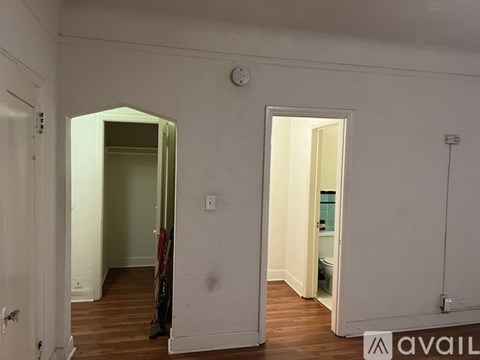 A room with a white door and a clock on the wall.