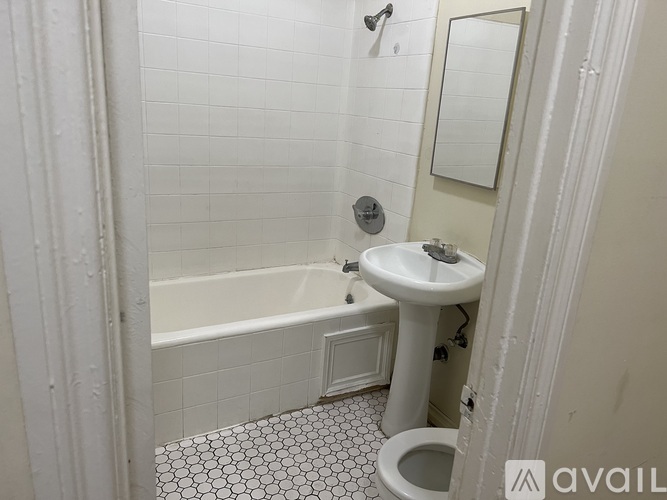 A white bathroom with a toilet, sink, and bathtub.