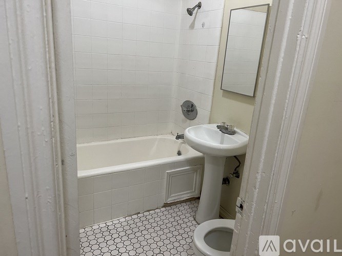 A white bathroom with a toilet, sink, and bathtub.