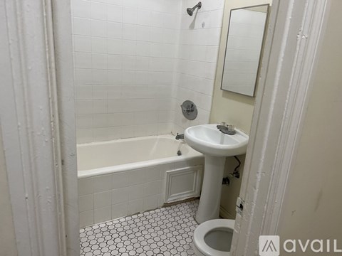 A white bathroom with a toilet, sink, and bathtub.