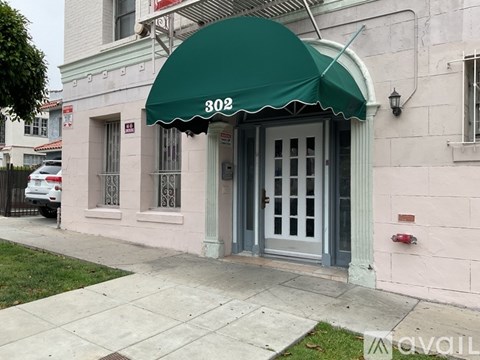 A building with a green awning and the number 302 on it.