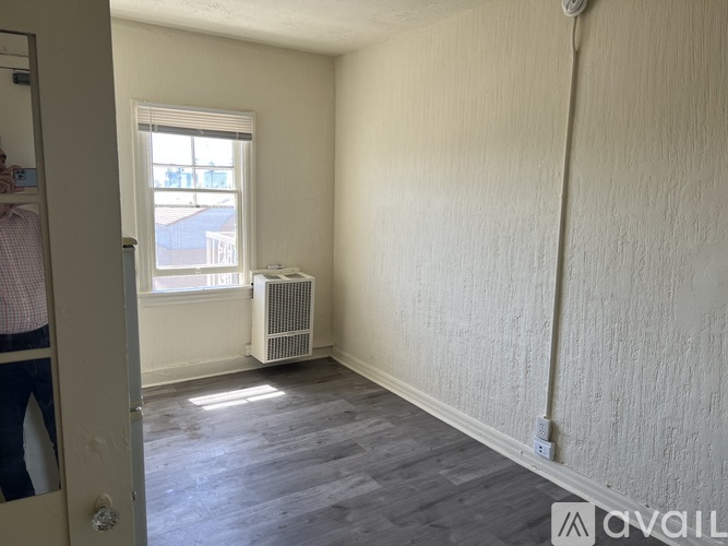 A room with a window and a radiator on the floor.