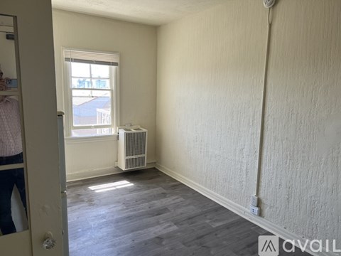A room with a window and a radiator on the floor.