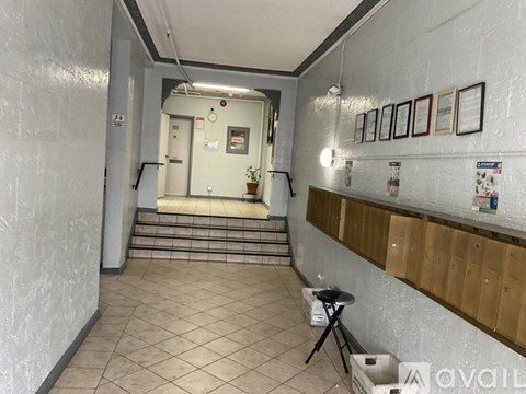 A hallway with a staircase leading to a door at the end.