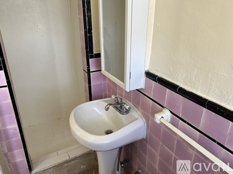 A white sink in a bathroom with pink tiles.