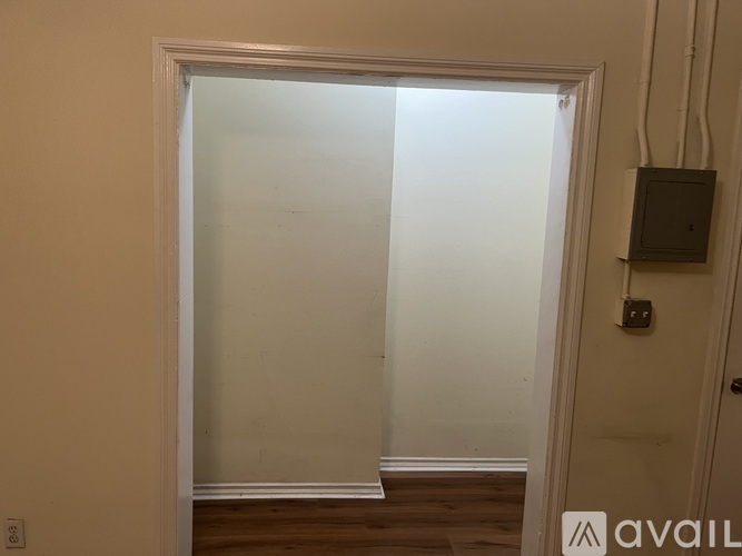 A room with a door and a wall socket.
