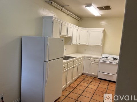 A kitchen with white appliances and cabinets.