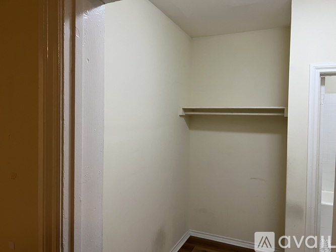 A small, empty room with a shelf and a door.