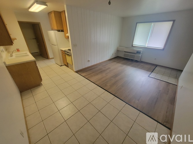 A kitchen with white appliances and wooden cabinets.